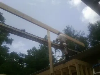 Carpenter setting a ridge beam over a new addition frame — Ice Dam Removal by Roofing Brothers in Pinetown