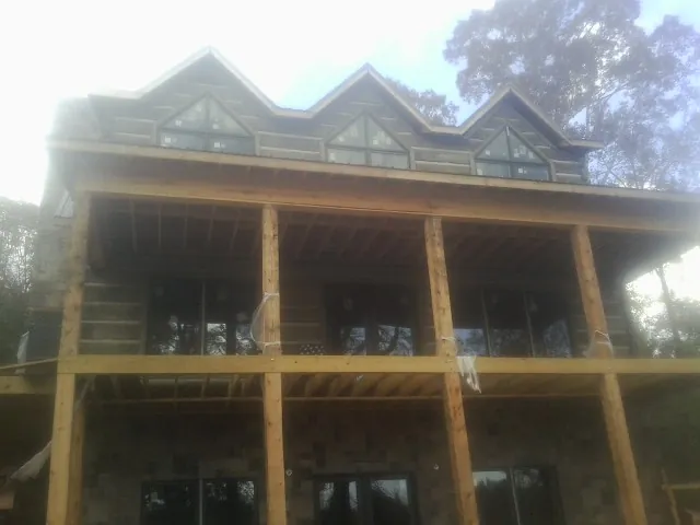 Dormers and porch framing on a large log home under construction — Roof Coating work by our crew in Pinetown